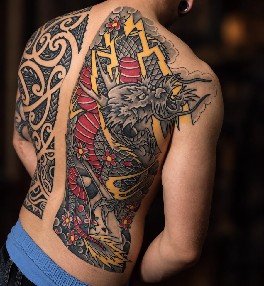 Drache mit Blitzen und Kirschblüten auf Rücken und Schulter – Tattoo aus Bad Bramstedt